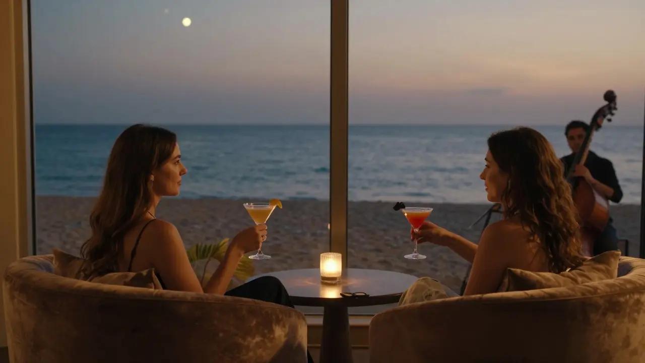 Couples relaxing in a beachside lounge with cocktails, ocean view under twilight sky.